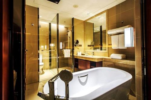a large bathroom with a tub and a shower at Ramada Jiaxing in Jiaxing
