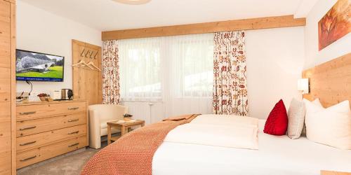a bedroom with a large white bed and a window at Bachmann Appartements in Sankt Anton am Arlberg