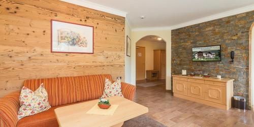 a living room with a couch and a wooden wall at Bachmann Appartements in Sankt Anton am Arlberg