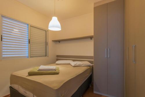 a bedroom with a bed with two towels on it at Apartamento Moderno Poços de Caldas in Poços de Caldas