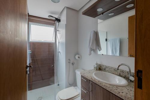 La salle de bains est pourvue d'un lavabo, d'une douche et de toilettes. dans l'établissement Apartamento Moderno Poços de Caldas, à Poços de Caldas