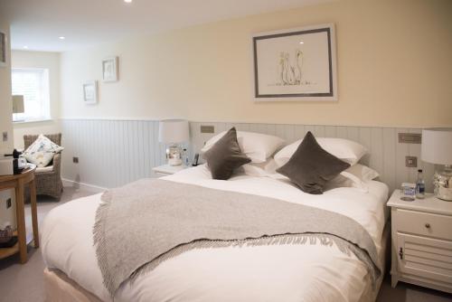 a bedroom with a large white bed with pillows at The Turtley Corn Mill in South Brent
