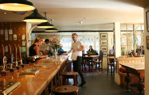 a man standing at a bar in a restaurant at The Turtley Corn Mill in South Brent
