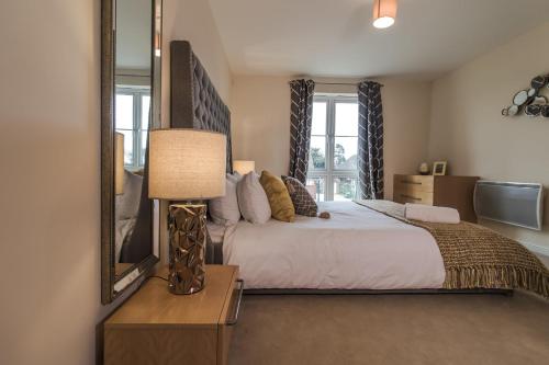 a bedroom with a large bed and a mirror at Trevelyan Court Apartments Windsor in Windsor