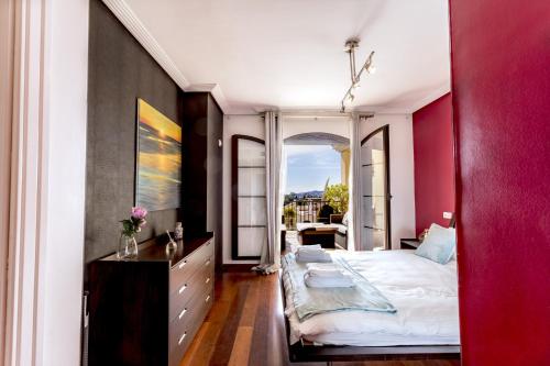 ベナアビスにあるEl Balcon Del Solの赤い壁のベッドルーム1室(大型ベッド1台付)