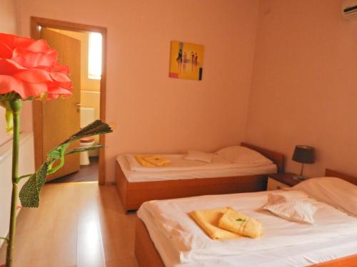a room with two beds and a vase with a flower at Pensiunea Caramell in Cluj-Napoca