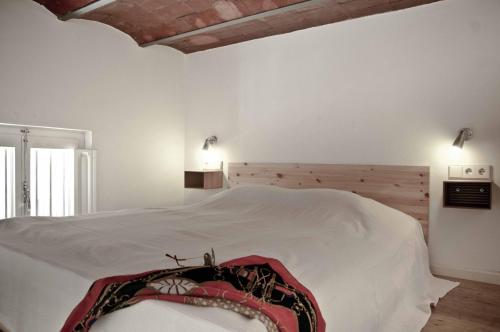 a bedroom with a large white bed with a wooden headboard at Barceloneta Suites Apartments Market in Barcelona