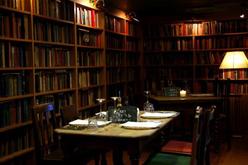 a library with a table with chairs and books at The Turtley Corn Mill in South Brent