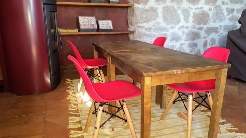 a wooden table with four red chairs around it at La Torre Blanca in Cardona