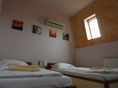 a bedroom with two beds and a window on the wall at Pensiunea Caramell in Cluj-Napoca