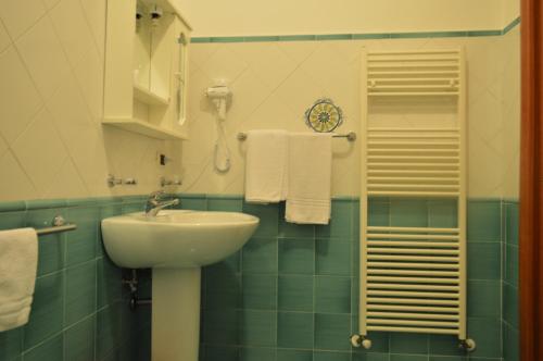 a bathroom with a sink and a shower with towels at B&B Scalea Rooms in Scalea