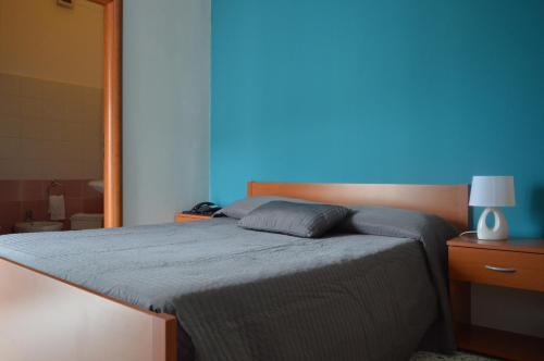 uma cama num quarto com uma parede azul em B&B Scalea Rooms em Scalea