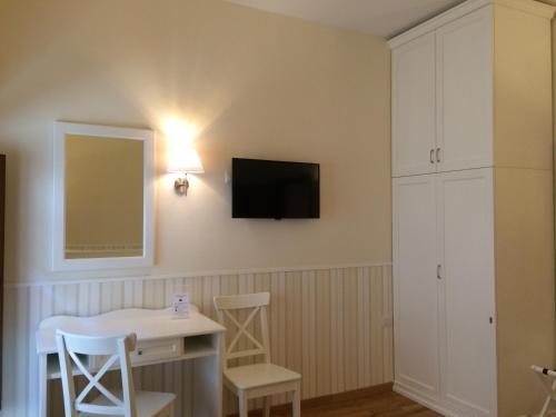 a room with a desk and a tv on the wall at Relais Duomo Adelaide in Florence