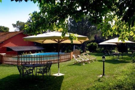 a group of tables and umbrellas next to a pool at Tenuta Agricola Fonte Di Papa in Monterotondo
