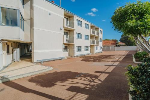 an empty sidewalk in front of an apartment building at Canning Bridge Auto Lodge in Perth