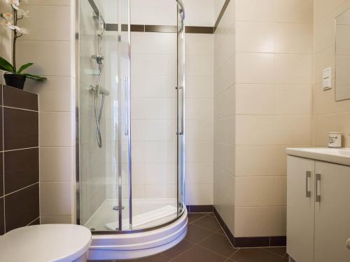 um chuveiro na casa de banho com um WC e um lavatório em VacationClub - Aquamarina Apartment C-06 em Świnoujście