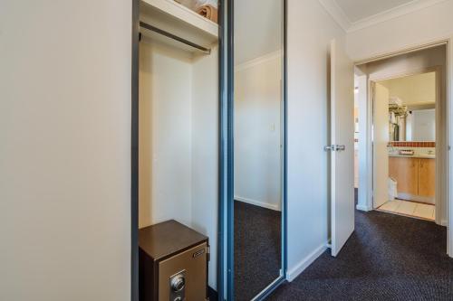 a room with a mirror and a closet at Canning Bridge Auto Lodge in Perth