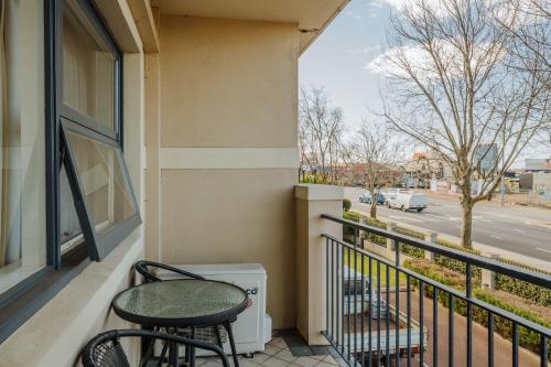 a balcony with a table and chairs and a street at Canning Bridge Auto Lodge in Perth