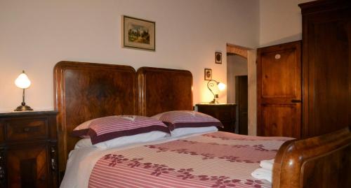 a bedroom with a bed with a wooden head board at Ala di Maniero in Agriturismo Valdrago in Toscana, nel Verde Mugello sulle Colline di Firenze Autodromo Mugello Circuit in Borgo San Lorenzo