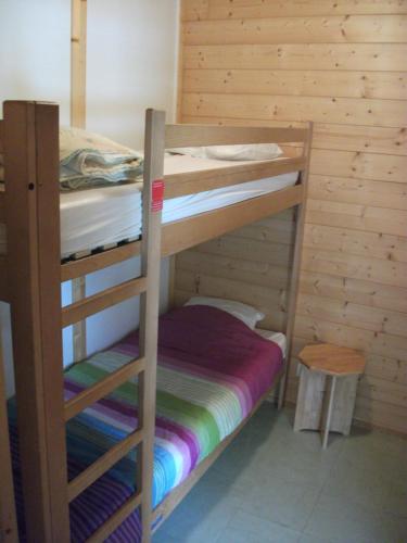 Cette chambre dispose de lits superposés avec 2 lits superposés et un tabouret. dans l'établissement Rev'ôthijol Vacances, à Auriolles