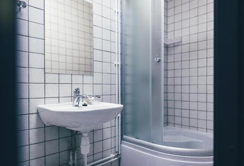 a white bathroom with a sink and a shower at Ülemiste Airport Hostel in Tallinn
