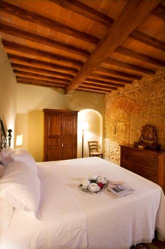 a bedroom with a large white bed with a wooden ceiling at Monsignor Della Casa Country Resort & Spa in Borgo San Lorenzo