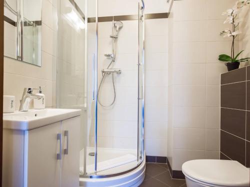 a bathroom with a shower and a toilet and a sink at VacationClub - Aquamarina Apartment C-05 in Świnoujście