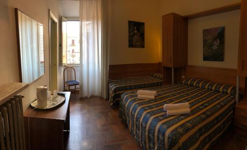 ローマにあるホテル ボロネーゼのベッド2台とテーブルが備わるホテルルームです。