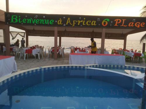 a sign over a swimming pool at a restaurant at Africa 6 Plage in Somone