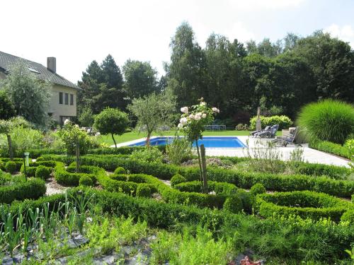 einen Hedge-Garten mit Pool im Hintergrund in der Unterkunft B&B Au Grenier in Gent
