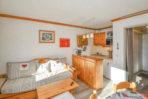 un salon avec un canapé et une cuisine dans l'établissement Residence Les Horizons d'Huez - maeva Home, à L'Alpe-d'Huez