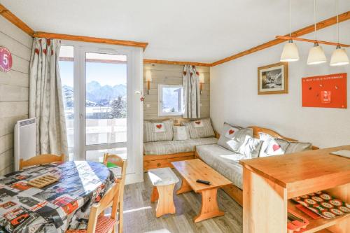un salon avec un canapé et une table dans l'établissement Residence Les Horizons d'Huez - maeva Home, à L'Alpe-d'Huez