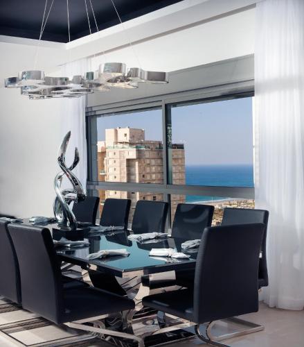 a conference room with a table and chairs and a large window at The Royal Penthouse in Bat Yam