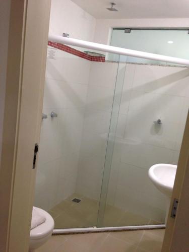 a bathroom with a shower with a toilet and a sink at Camboinhas Beach Pousada in Niterói