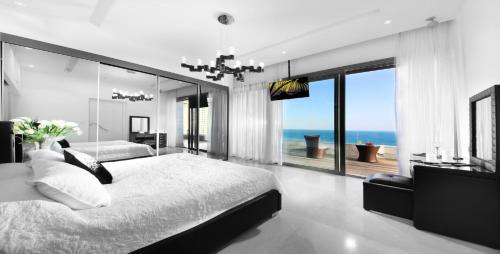 a bedroom with a bed and a view of the ocean at The Royal Penthouse in Bat Yam