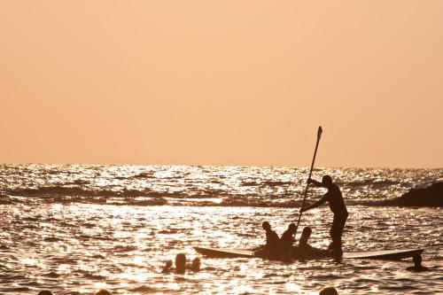 a man standing on a paddle board on the beach at The Royal Penthouse in Bat Yam