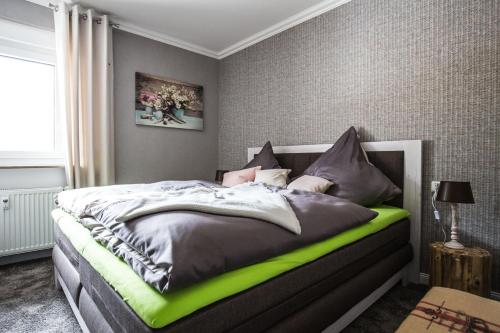 ein Schlafzimmer mit einem Bett mit einem grünen Bettrahmen in der Unterkunft Landhaus Heinrichs Willingen in Willingen