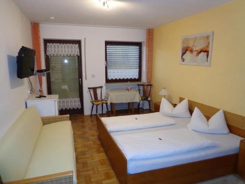 a bedroom with two beds and a couch and a table at Pension Schamberger in Neukirchen beim Heiligen Blut