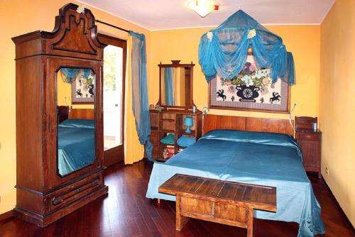 1 dormitorio con cama de madera y vestidor en B&B La Colombera, en Lessona