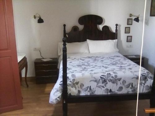 Un dormitorio con una cama con un edredón blanco y negro. en Casa Mamá Conchita Vivienda Vacacional, en Los Silos