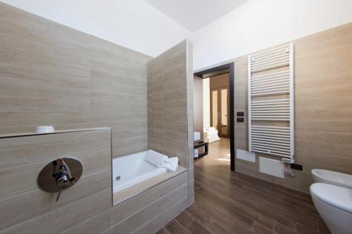 bagno con lavandino, vasca e servizi igienici di Arena Luxury Rooms a Verona