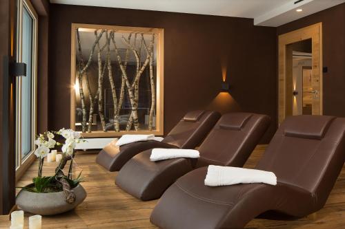 a living room with brown leather reclining chairs at Familien- und Wellnesshotel "Landhaus Viktoria" in Oberstdorf