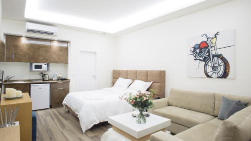 a living room with a bed and a couch at The Stay Furnished Apartments in Dbayeh