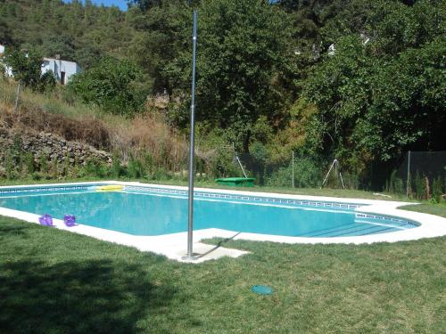una piscina vuota nell'erba con un palo di Ocio Aventura Rural a Los Romeros