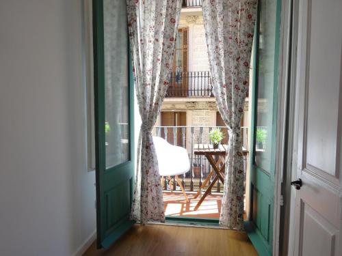 eine offene Tür, die auf einen Balkon mit einem Stuhl führt in der Unterkunft Barcelona Just Like Home in Barcelona