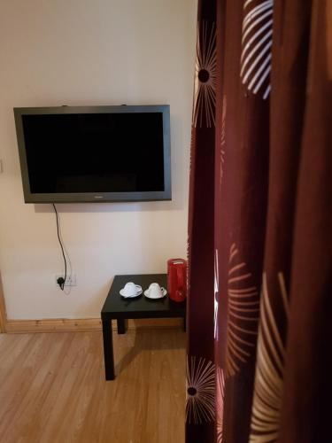 a living room with a table and a flat screen tv at Ashemere Lodge in Clondalkin 