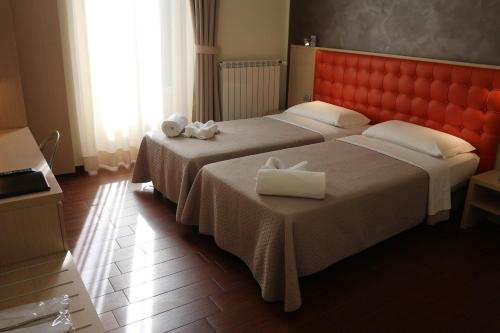 two beds in a hotel room with towels on them at Hotel La Madonnina in Milan