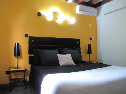 - une chambre avec un grand lit et un mur jaune dans l'établissement Vert Lagon, à La Saline les Bains