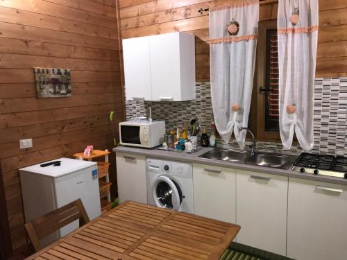 a kitchen with a sink and a washing machine at Chalet Impero in Scauri