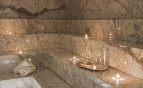 un baño con una bañera de mármol con velas. en Yoo Deluxe Apartamento, en Punta del Este